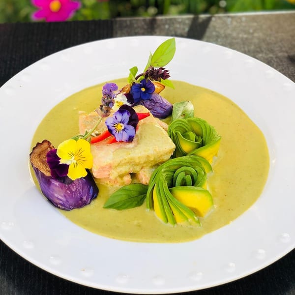 Siam Nara Thai Cuisine's green curry with salmon, avocado roses, purple eggplant, and edible flowers.
