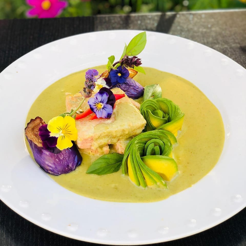 Siam Nara Thai Cuisine's green curry with salmon, avocado roses, purple eggplant, and edible flowers.