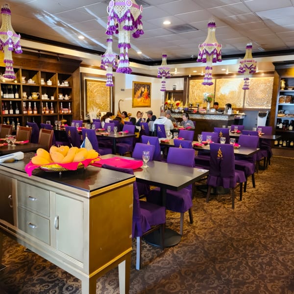 Siam Nara Thai Cuisine dining room with purple chairs, ornate decor, and a mango display.